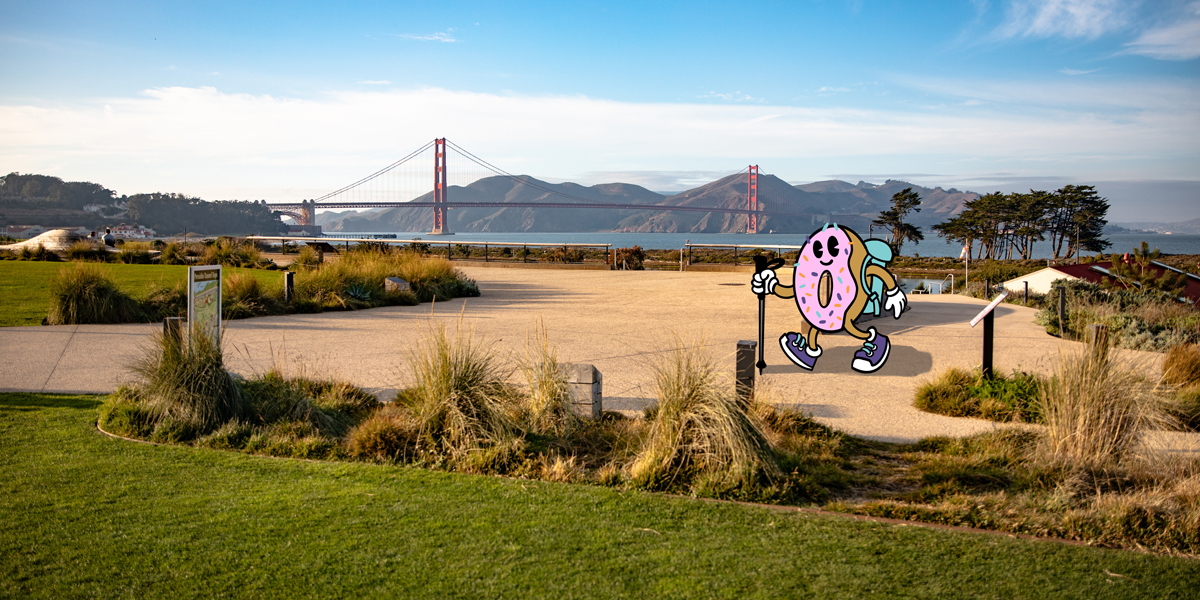 a scenic view from the Presidio Tunnel Tops in San Francisco, with a cartoon donut hiking along as part of the Golden Gate Dozen Trail