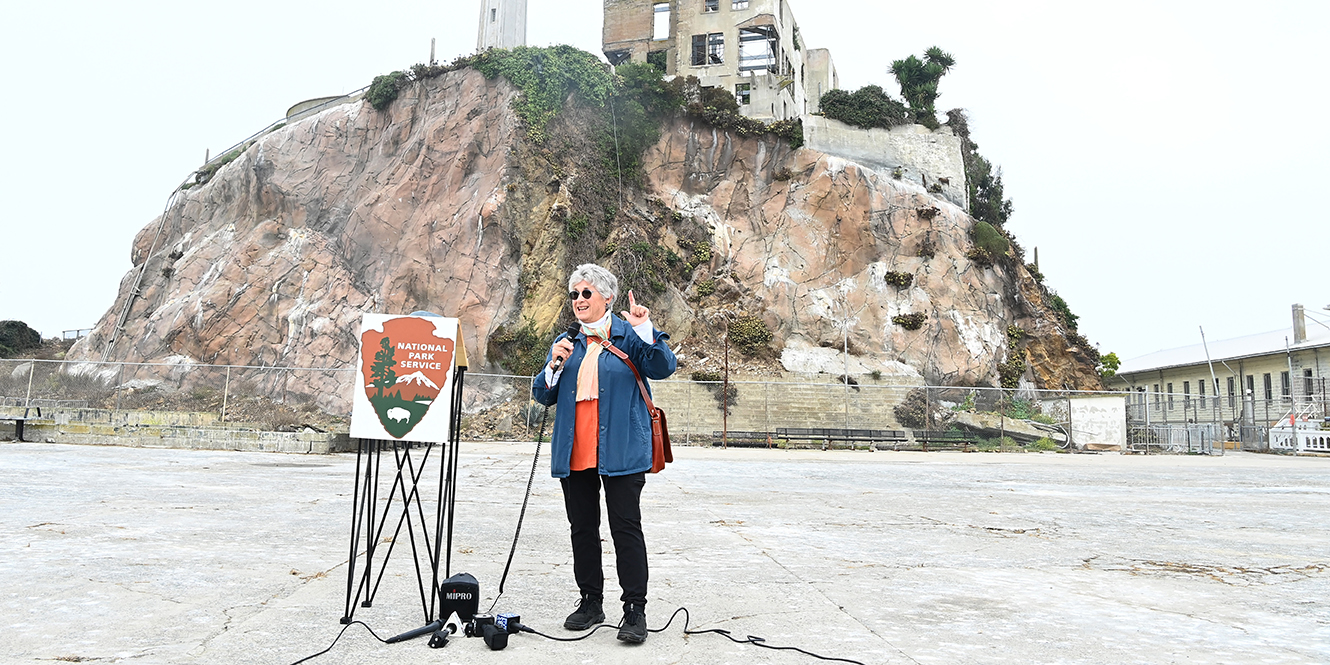 Jolene Babyak stands on the parade grounds on Alcatraz Island in front of reporters.