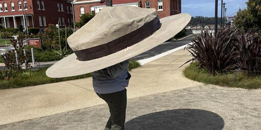 Person wearing an oversized a NPS park ranger flat hat.