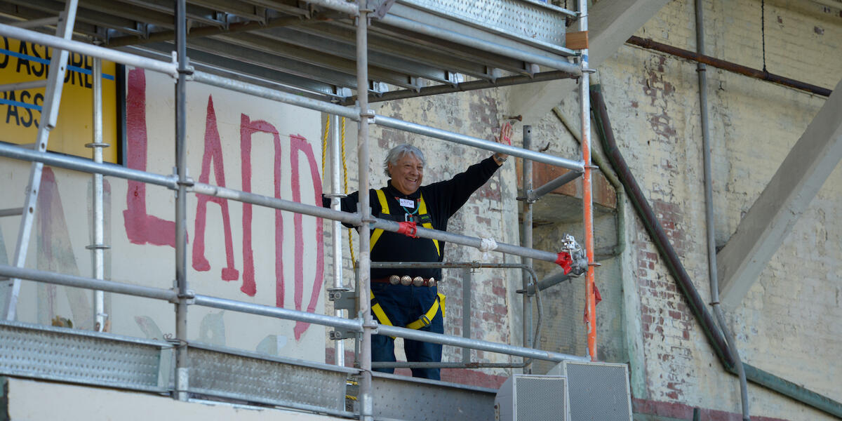 Alcatraz occupier waves after painting political slogan during 50th anniversary celebration