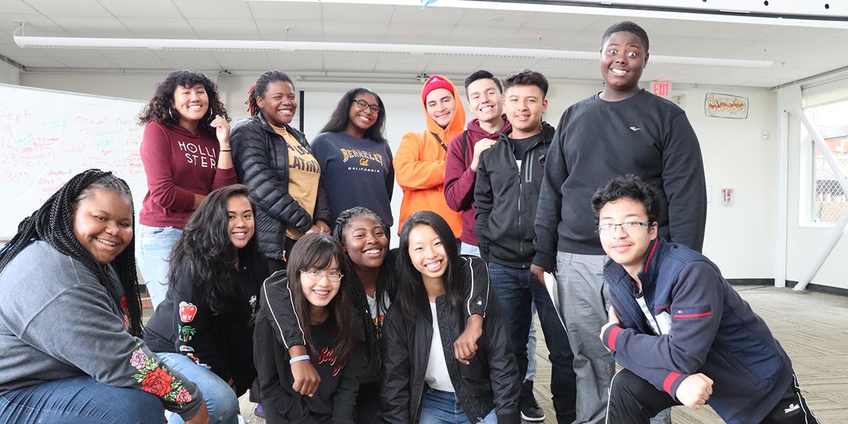 2017 I-YEL Cohort inside the Crissy Field Center A group of smiling teenagers poses together inside of a room.