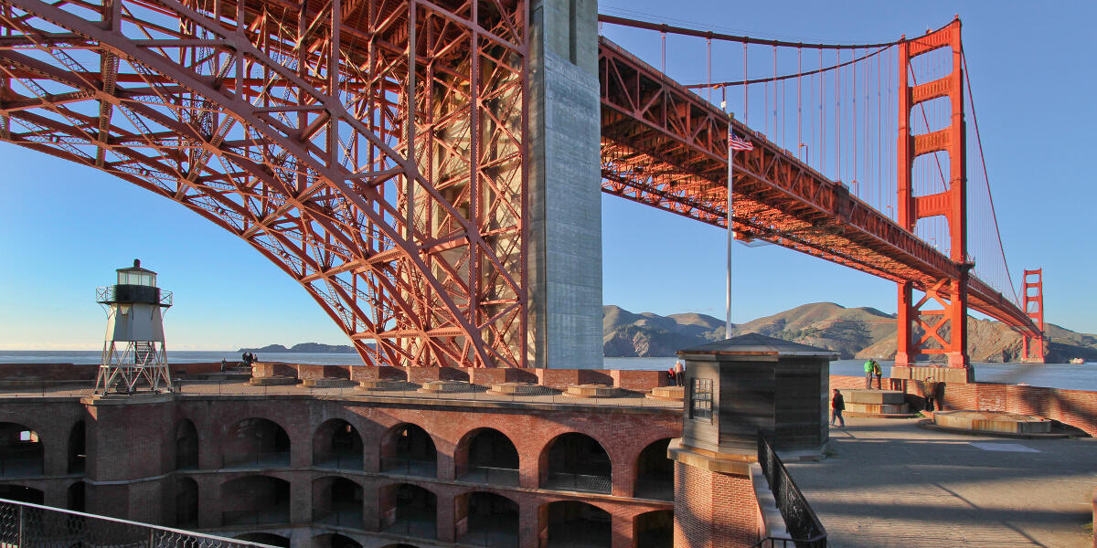 View of the Golden Gate Bridge and the top of Fort Point National Historic Site set against a blue sky