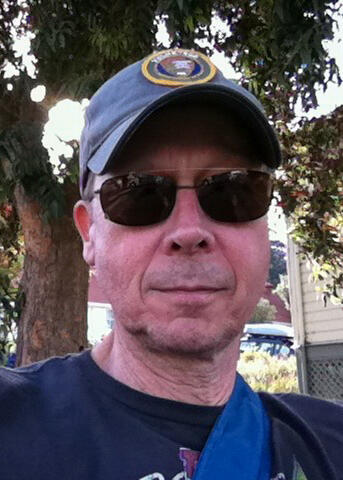 Portrait of a man wearing sunglasses and an NPS Volunteer hat.