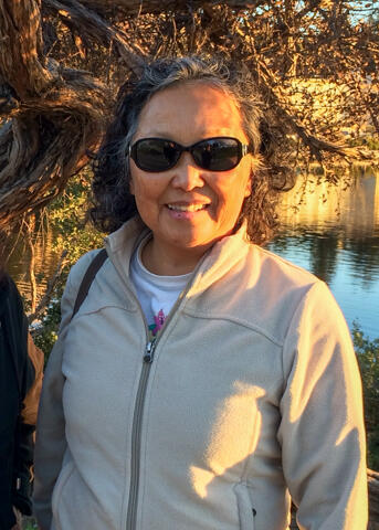 A portrait of a woman outdoors surrounded by nature