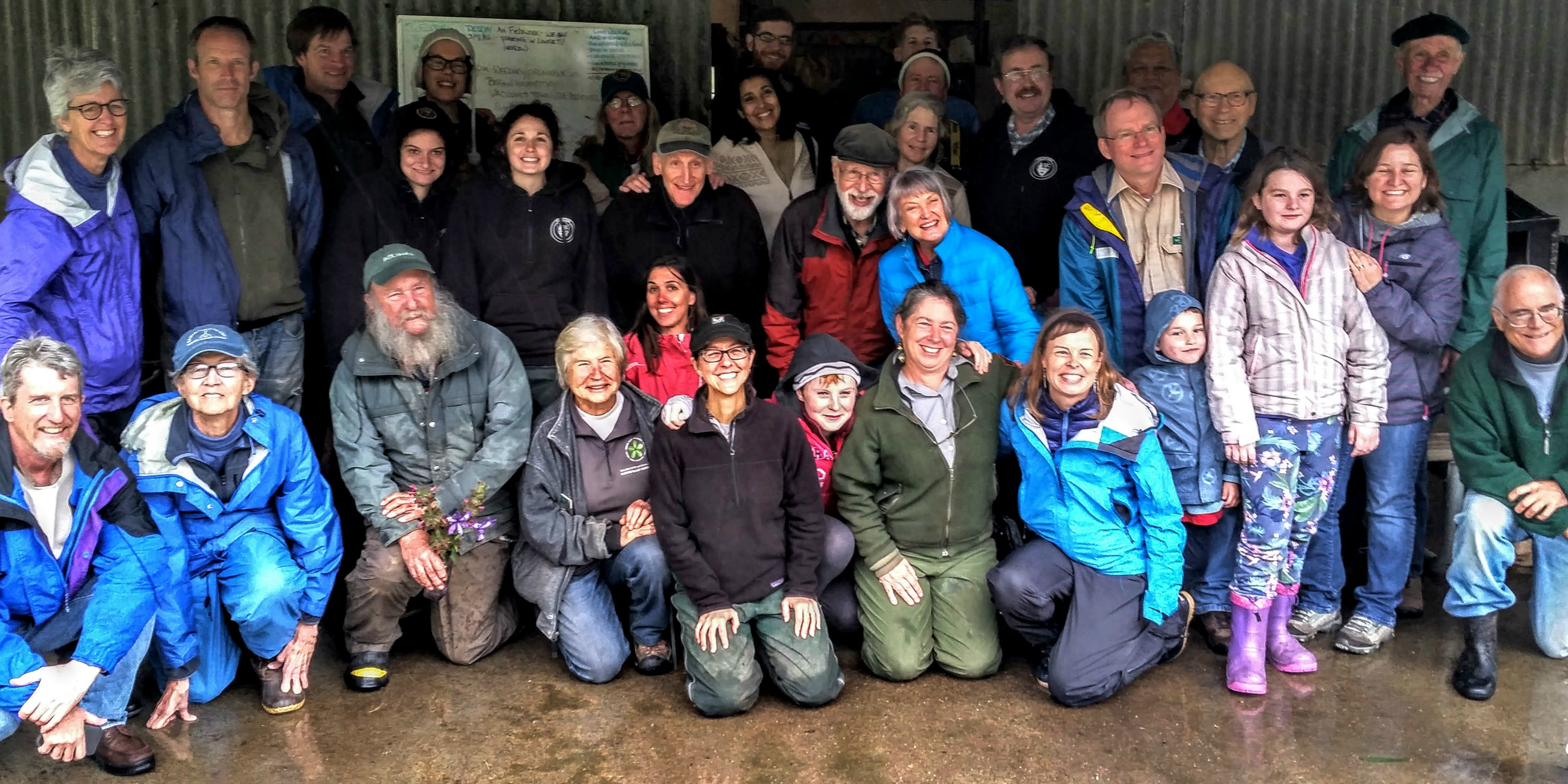 Tennessee Valley large group A large group smiles while posing for a photo in front of a metal barn.