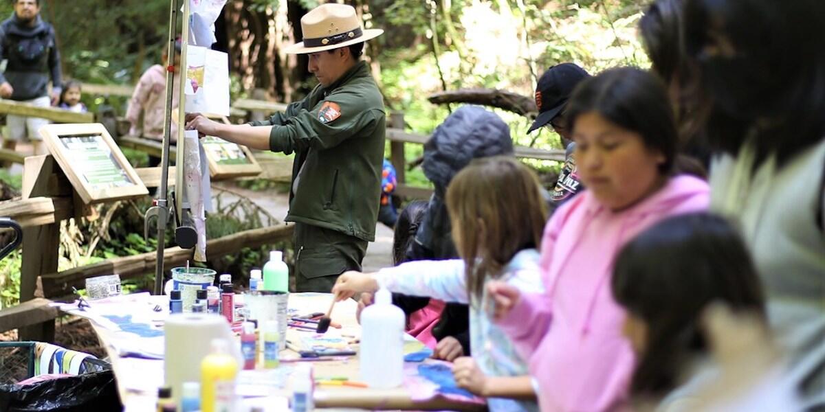 NPS Ranger hangs up watercolor art.