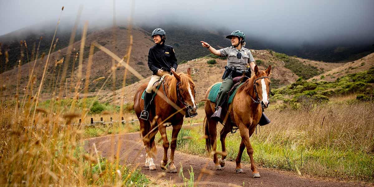 Lainie Motamedi, left, and Park Ranger Katlyn Grubb ride out from the Horse Mounted Patrol Stables in the Marin Headlands.