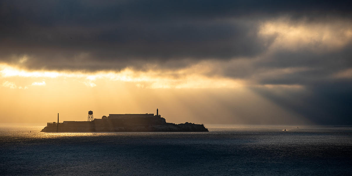 Sunlight breaks through gloomy fog over Alcatraz Island