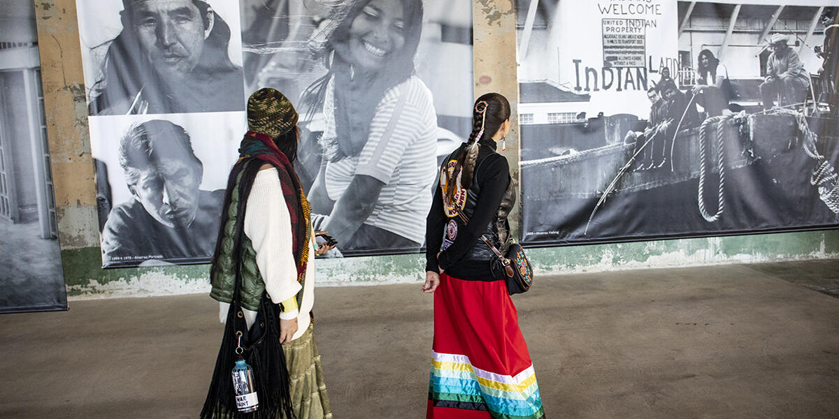 women walk past black and white photos