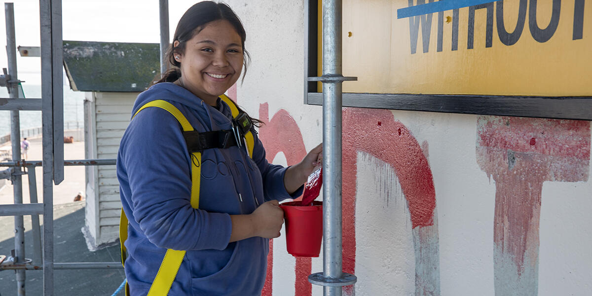 girl posing for picture with paintbrush