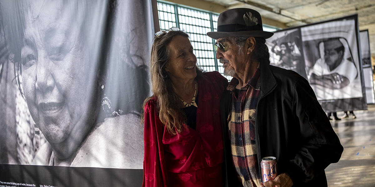 man and woman surrounded by black and white photos