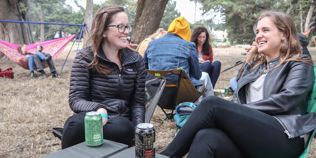 Two women sitting outside in the middle of a conversation.