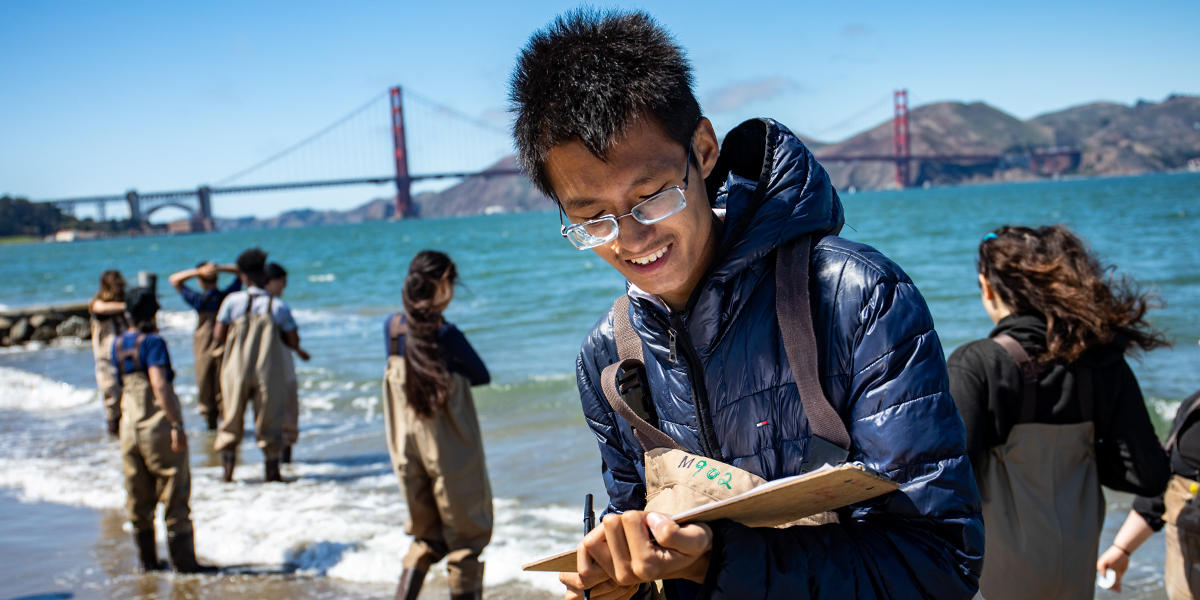 Youth participating in Project WISE are mentored by staff from the Crissy Field Center as they learn about water testing in the Marsh at Crissy Field.