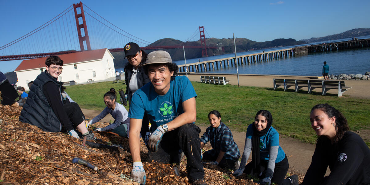 Interns smile for a photo while doing park stewardship work at Crissy Field.