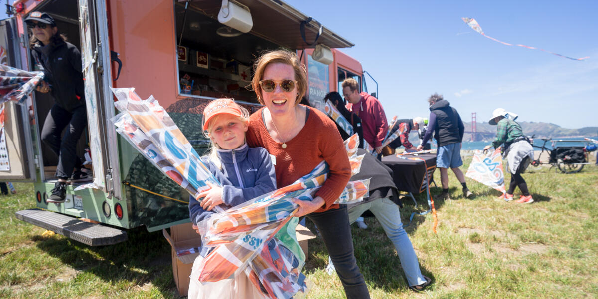 Conservancy staff and family help hand out kites at Crissy Field Kite Day