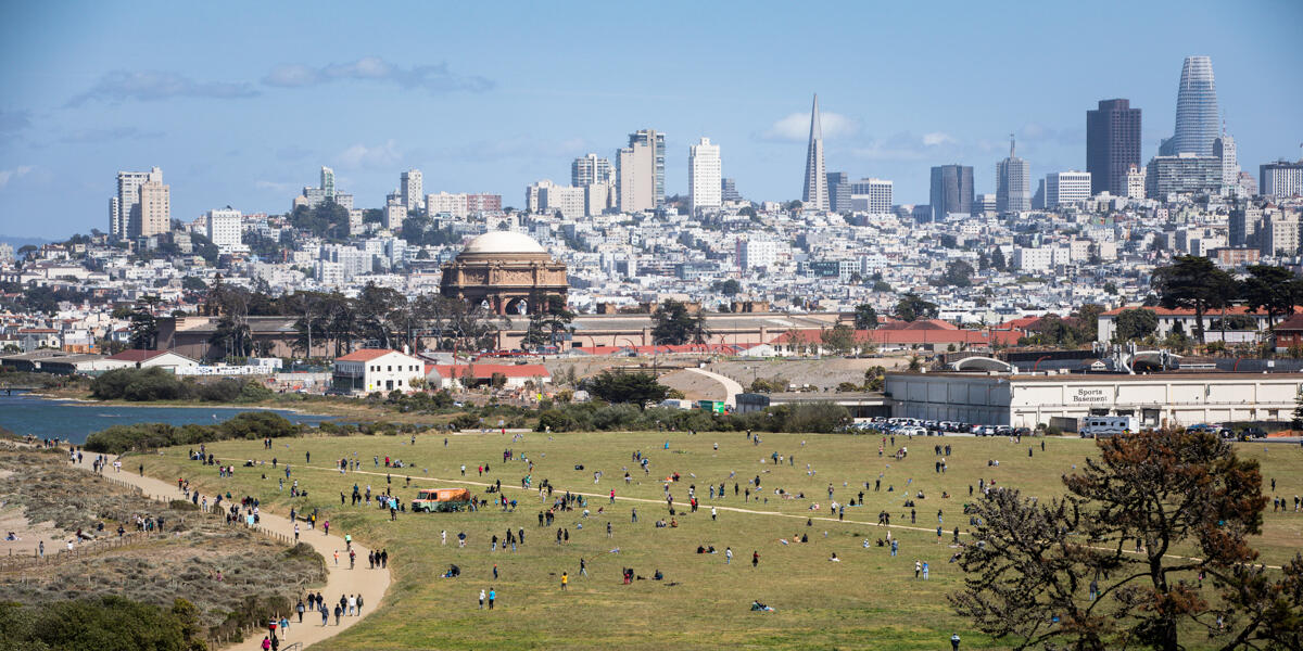 A crowd is gathered at Crissy Airfield on a beautiful day in San Francisco