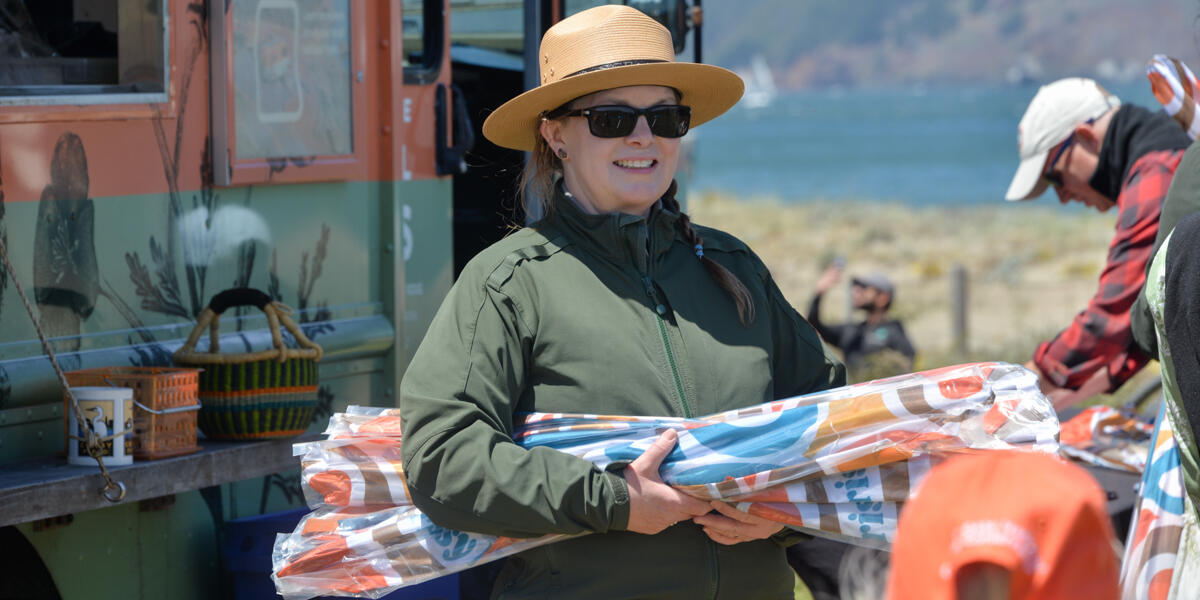 NPS ranger holding kites to distribute at the Crissy Field Kite Day event