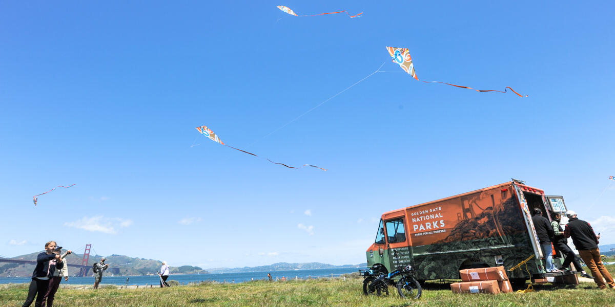 Children fly kites nearby the Roving Ranger at Crissy Field.
