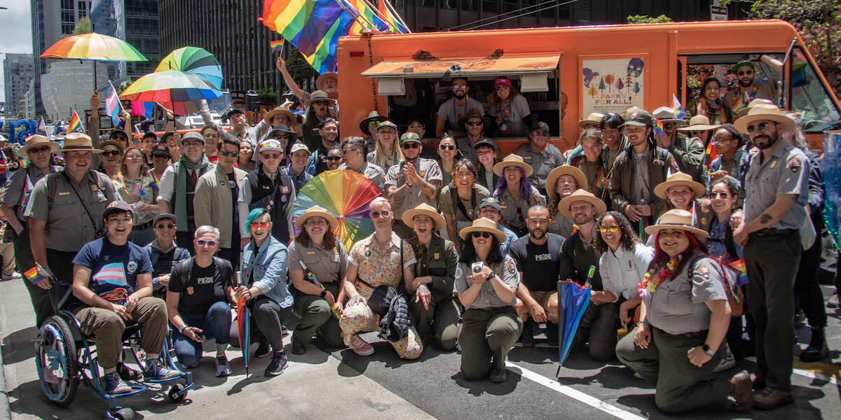 Staff from the Parks Conservancy, National Park Service and the Presidio Trust pose for a group photo during the 2023 Pride Parade.