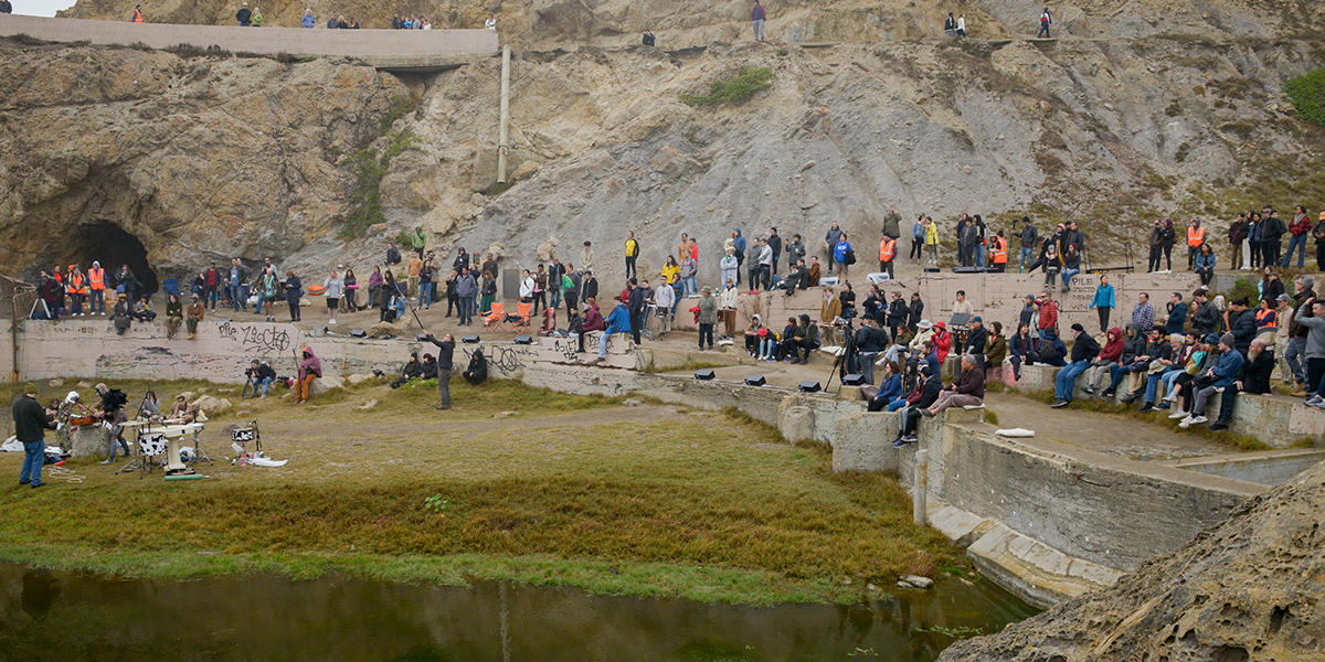 Musicians perform in front of crowd of onlookers at Sutro Baths.