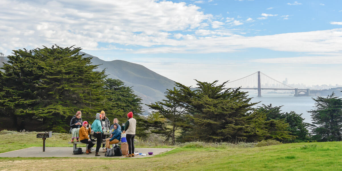 People sit at a park picnic table in the Marin Headlands
