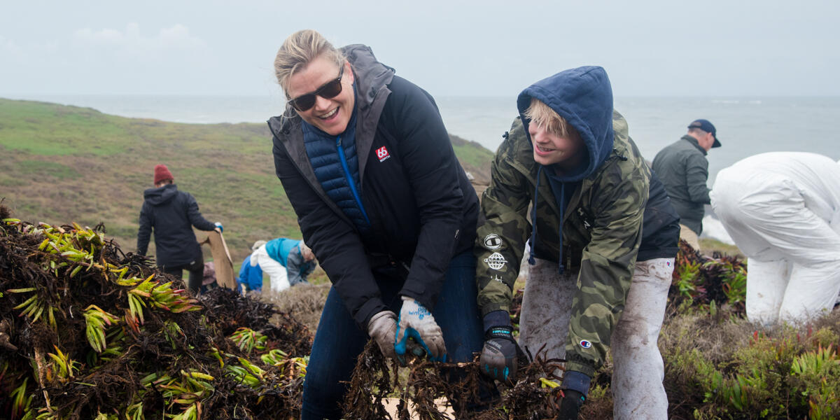 Volunteers smiling while removing ice plant in the Marin Headlands