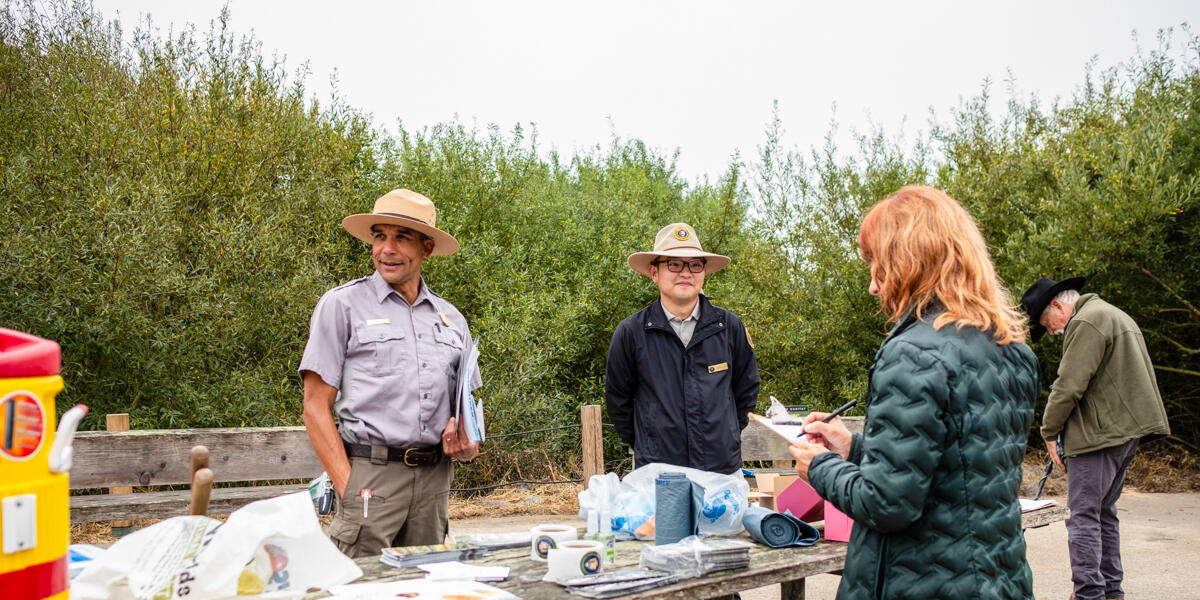 NPS rangers check in volunteers at Coastal Cleanup Day 2024 in Muir Beach