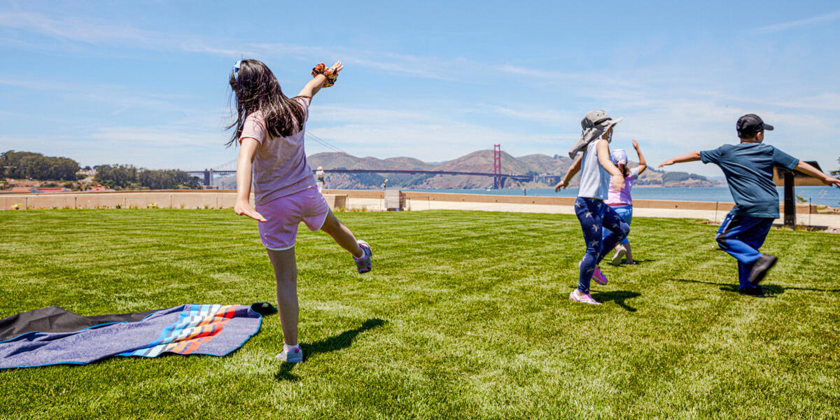 Kids play at the Golden Gate Meadow Kids stretch and play, running around the Presidio Tunnel Tops lawn.