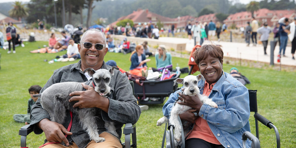 A couple relaxing at Presidio Tunnel Tops with their two dogs.