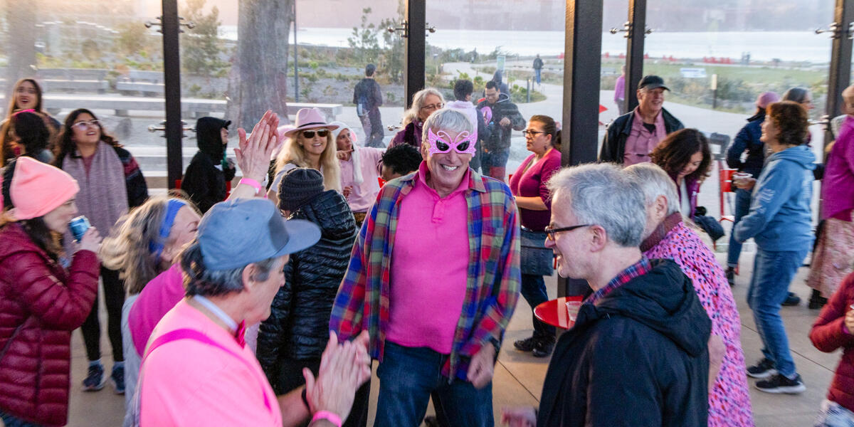 People dressed in pink joyfully dancing and celebrating at the Pink Full Moon party in the San Francisco Presidio