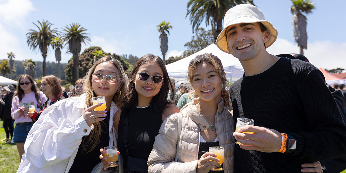 A group of friends pose with tasting glasses at Parks4All: Brewfest, a beer festival and fundraiser, on Saturday, July 29th, 2023 in the Presidio of San Francisco.