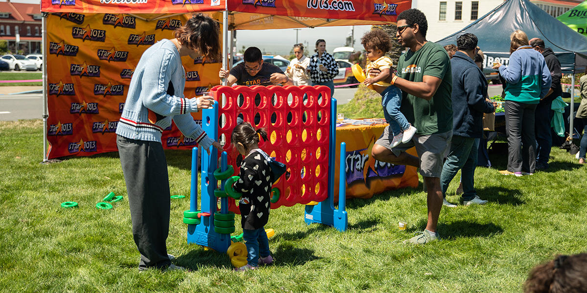 A kid plays Connect Four at Parks4All: Brewfest, a beer festival and fundraiser, on Saturday, July 29th, 2023 in the Presidio of San Francisco.