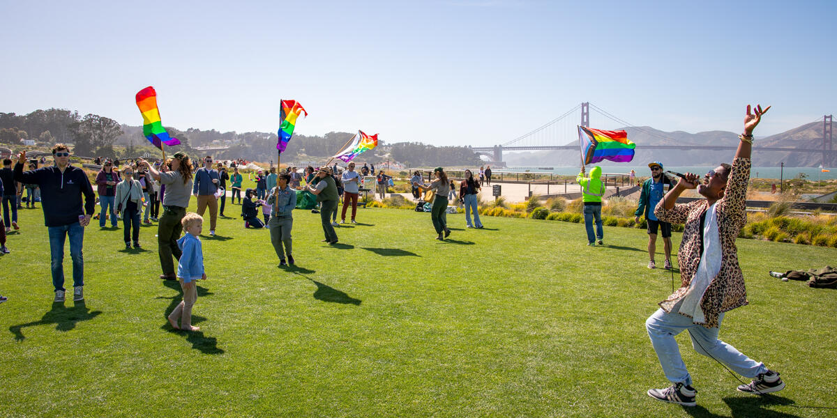 Park visitors dancing, singing, and celebrating at Pride in the Presidio, San Francisco.