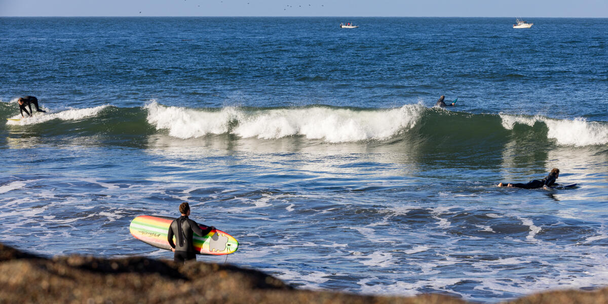 Surfers catch waves on a sunny day at Rodeo Beach in the Marin Headlands