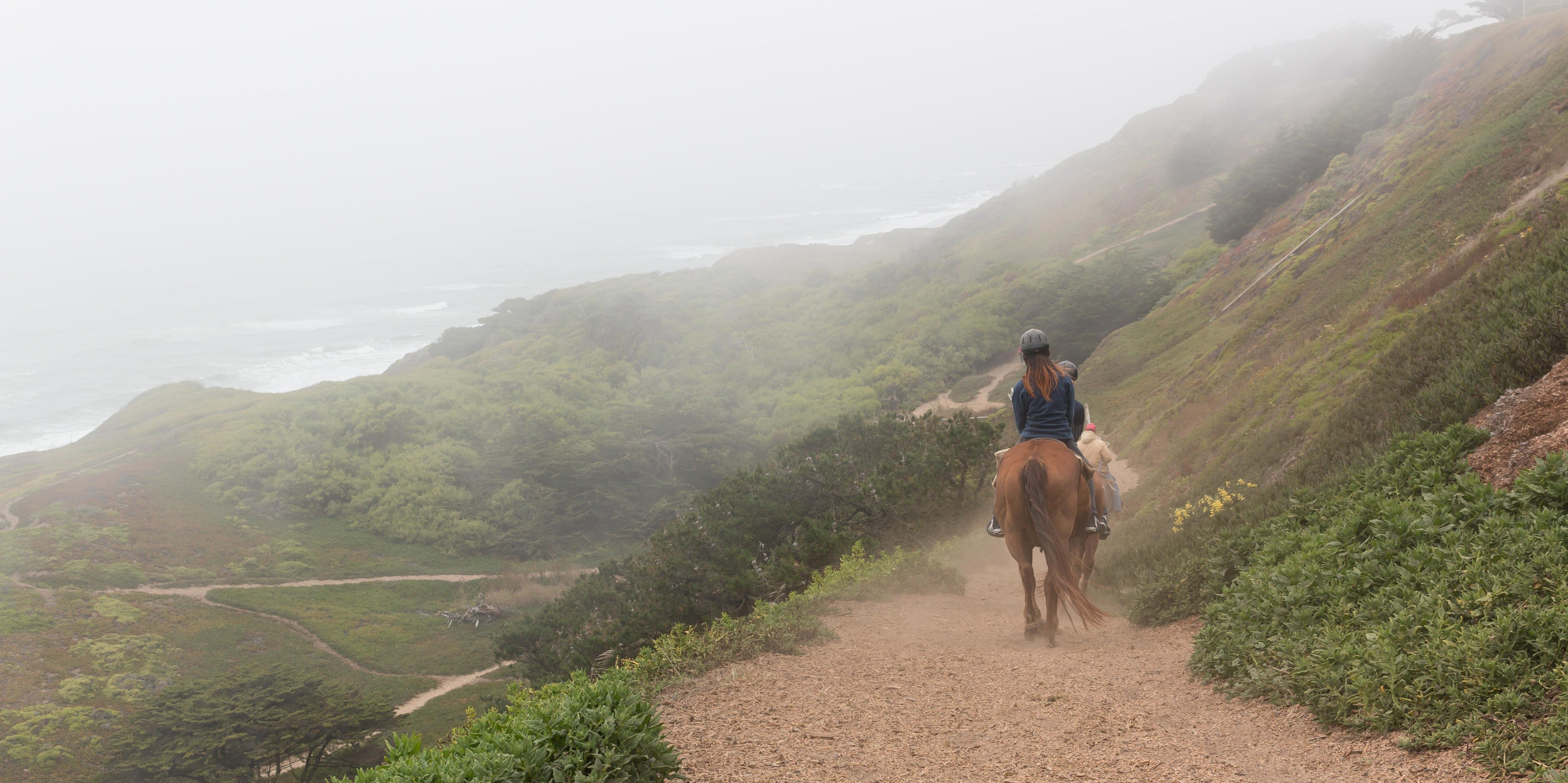 Equestrians ride through foggy Fort Funston