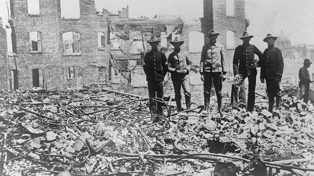 Soldiers in San Francisco stand amongst ruins and rubble after the 1906 earthquake 
