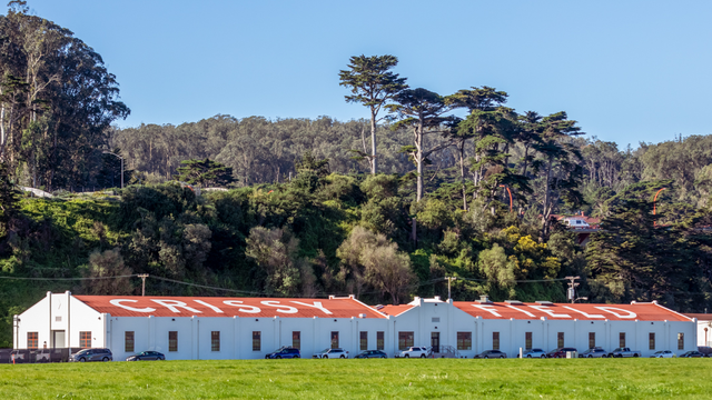Two historic hangar buildings with the words 'Crissy Field' painted on the roof, a throwback to it's days as an airfield.