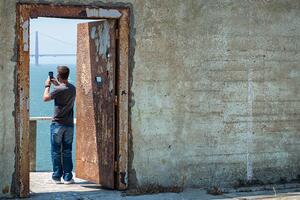 A visitor takes a photo on Alcatraz Island.