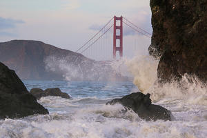 Waves crash before the Golden Gate Bridge