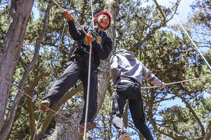 Two youth at the top of a ropes course