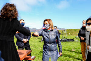 Speaker Nancy Pelosi elbow bumps to greet attendees at Crissy Field's 20th anniversary address