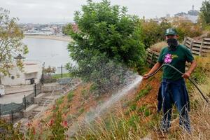 A volunteer waters plants at Black Point Historic Gardens