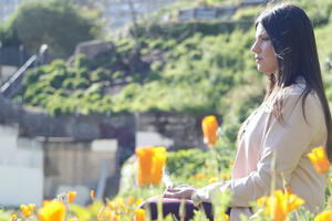 Sharaya Souza sits surrounded by orange poppies.