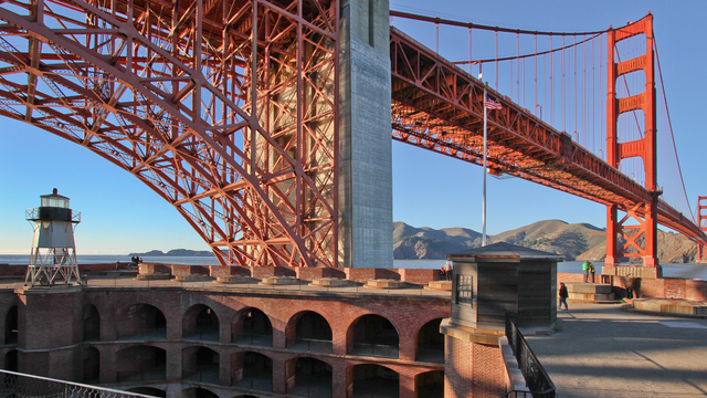 View of the Golden Gate Bridge and the top of Fort Point National Historic Site set against a blue sky