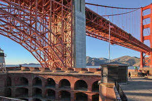 View of the Golden Gate Bridge and the top of Fort Point National Historic Site set against a blue sky