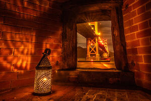 A lantern cast shadows on brick walls at Fort Point.