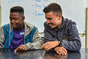 A Crissy Field Center educator a teenage youth look over images inside the Crissy Field Center facility