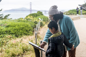 A family checks out a StoryWalk at Lands End in San Francisco.