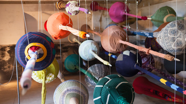 A barrage of weapons suspended in flight reveals itself on closer inspection to be an assortment of obscure objects made from secondhand clothes, worn fabric, and crocheted scraps