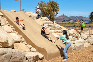 Children playing on Bluff Slide at Outpost
